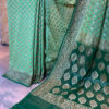 Banarasi Khaddi Georgette Light Green saree with small paisley copper zari boota Bottle Green border and anchal with heavy zari floral bel boota work